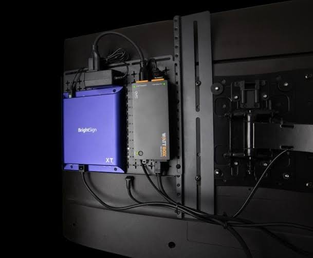 BrightSign XT digital signage player mounted behind a commercial display alongside connected AV hardware.